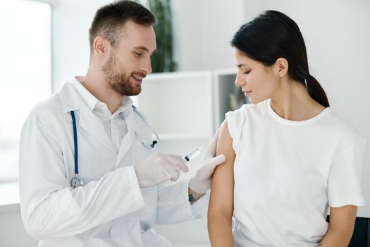 doctor in hospital giving injection to female patient vaccine protective gloves. High quality photo