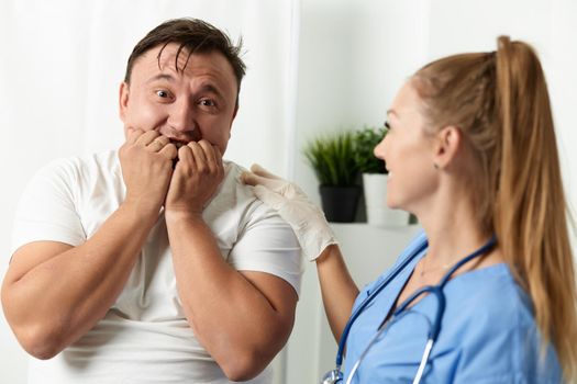 scared patient next to woman doctor hospital fear. High quality photo