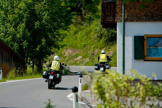 Plansee lake, Austria - June 20, 2017: Motorcyclists are driving along the road along the lake.