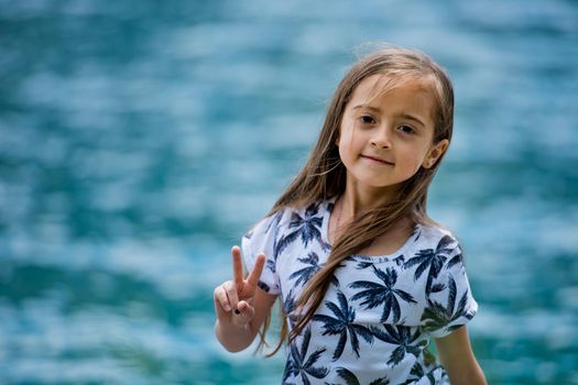 Portrait of a cute girl on a turquoise water background.