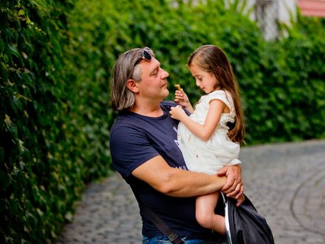 The father holds his little daughter in his arms. Father's Day.