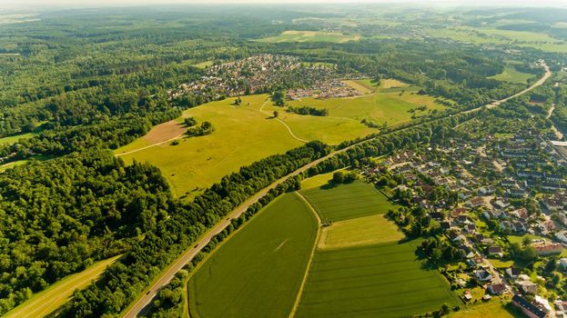 Aerial view of asphalt road passes through the field.