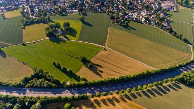 Aerial view of asphalt road passes through the field.