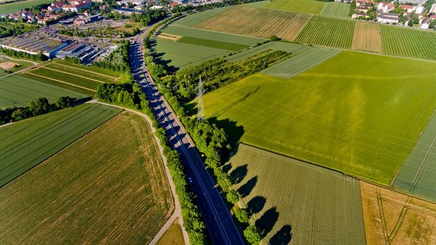 Top view of asphalt road passes through the field.