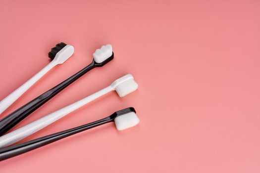 Fashionable toothbrush with soft bristles. Popular toothbrushes. Hygiene trends. Kit of toothbrushes on pink background.