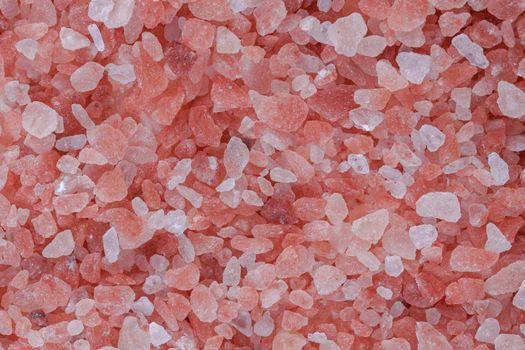 Close up background texture of small fine ground crystals pink Himalayan salt, elevated top view, directly above.