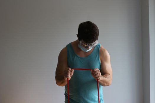 COVID fitness related photos. Man works out with mask . High quality photo