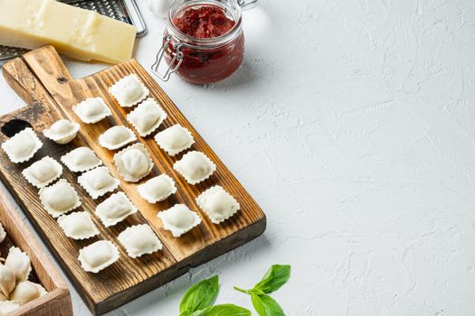 Homemade fresh Italian ravioli pasta set on wooden board, on white background , with copyspace and space for text
