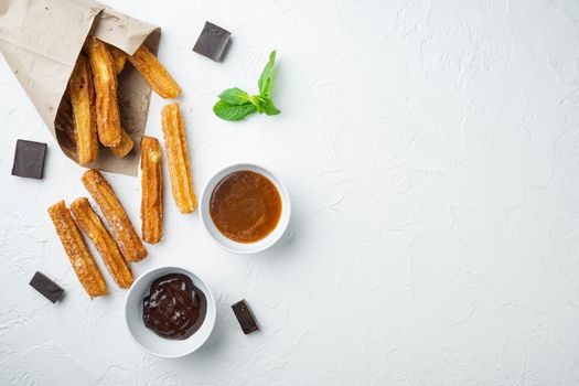 Churros with caramel, Traditional Spanish cusine, on white background, top view flat lay with space for text, copyspace