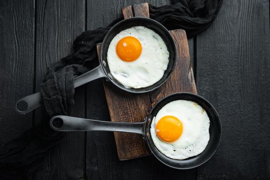 Fried Egg with ingredient in cast iron frying pan, on black wooden table background, top view flat lay