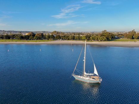 Aerial view of small sail boats in the Mission Bay of San Diego, California, USA. Small sailing ship yachts anchored in the bay. March 22nd, 2020