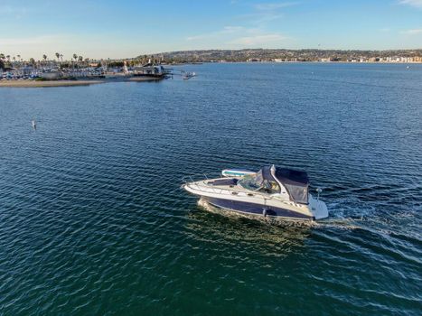 Aerial view of small speed boat in the Mission Bay of San Diego, California, USA. Small power boat yachts cruising on a calm water in the bay. March 22nd, 2020