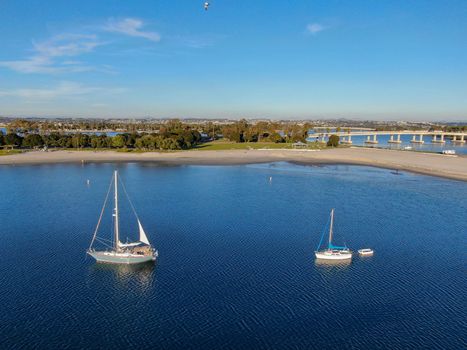 Aerial view of small sail boats in the Mission Bay of San Diego, California, USA. Small sailing ship yachts anchored in the bay. March 22nd, 2020