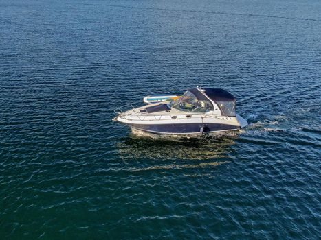 Aerial view of small speed boat in the Mission Bay of San Diego, California, USA. Small power boat yachts cruising on a calm water in the bay. March 22nd, 2020