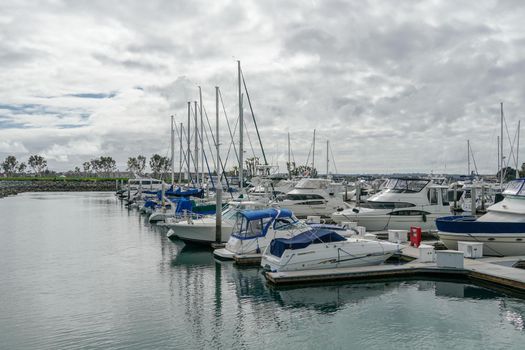 Boats moored at Embarcadero Marina Park North, San Diego. Boat, yachts, ship and sail docked at the harbor. Marina with anchored luxury boats. California. USA. January 16th, 2021