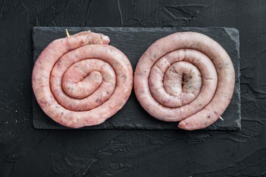 Spiral pork meat sausage set, on black background, top view flat lay