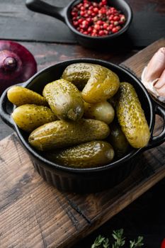 Marinated cucumbers gherkins set, on old dark wooden table background