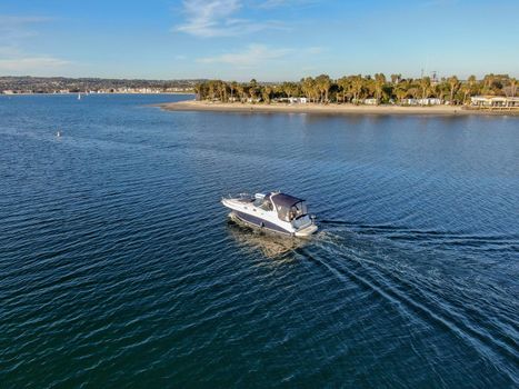 Aerial view of small speed boat in the Mission Bay of San Diego, California, USA. Small power boat yachts cruising on a calm water in the bay. March 22nd, 2020