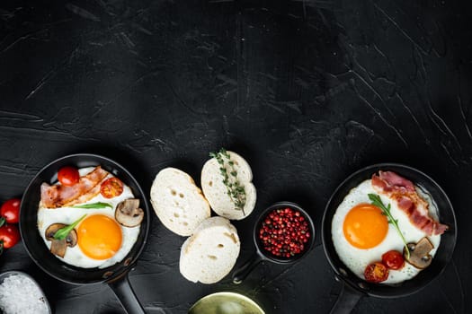 Fried eggs with cherry tomatoes and bread for breakfast in cast iron frying pan, on black background, top view flat lay , with space for text copyspace