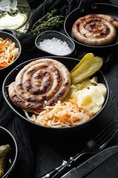 Bavarian sausage mashed potatoe and sour cabbage, on black background