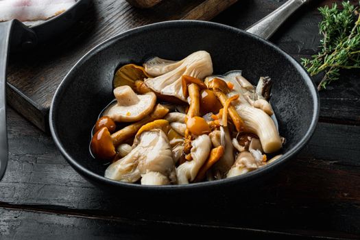 Wild mushrooms Boletus edulis and cap boletus in a jar set, on old dark wooden table background
