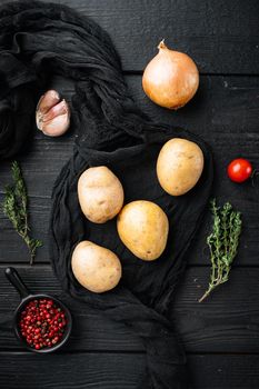 Fresh Pile of potatoes set, on black wooden table background, top view flat lay