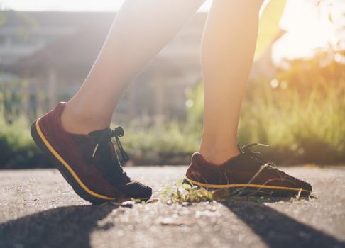 Woman wear running shoe on to walking and running on nature green background.Health exercise concept.