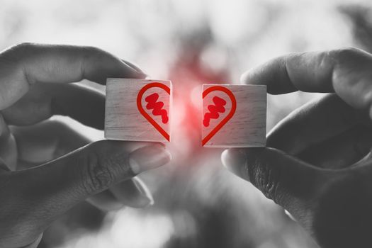 Hand hold wooden cube with heart sign icon on and copy space nature sunlight you can put text on background. Valentine love season concept.