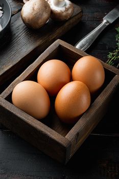 Fresh eggs on paper egg box set, on old dark wooden table background