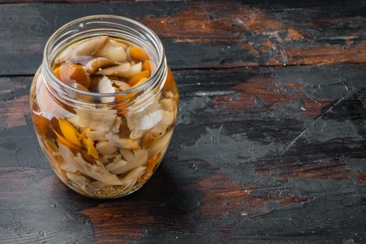 Marinated mushrooms set, on old dark wooden table background , with space for text copyspace
