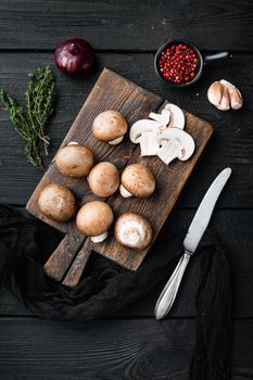 Brown champignons mushroom set, on black wooden table background, top view flat lay