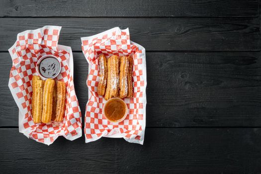 Fried Crullers in Brown, Take Away Bag in paper tray, on black wooden table background, top view flat lay with space for text, copyspace