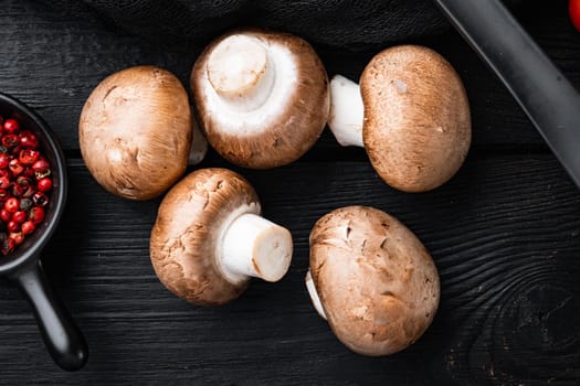 Raw mushrooms champignons set, on black wooden table background, top view flat lay