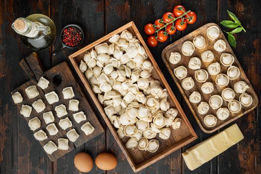 Raw Italian ravioli tortellini with fresh parmesan and basil , tomatoes set on old dark wooden table background, top view flat lay