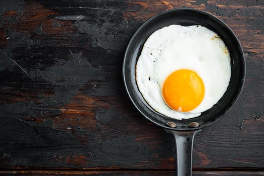 Fried Egg with ingredient in cast iron frying pan, on old dark wooden table background, top view flat lay , with space for text copyspace