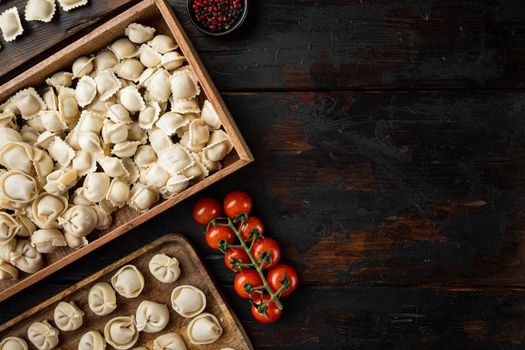Raw Italian ravioli tortellini with fresh parmesan and basil , tomatoes set on old dark wooden table background, top view flat lay , with copyspace and space for text