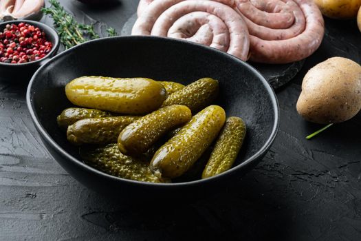 Pickled cucumbers, on black background