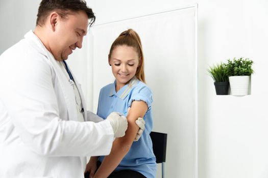 male doctor treating a patient an injection in a hospital. High quality photo