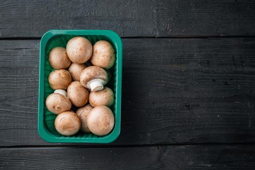 Royal champignons, Parisian champignons set, on black wooden table background, in plastic pack, top view flat lay , with space for text copyspace