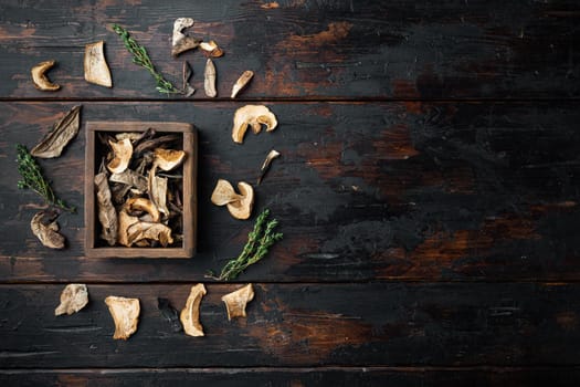 Wild organic dried porcini mushroom set, on old dark wooden table background, top view flat lay , with space for text copyspace