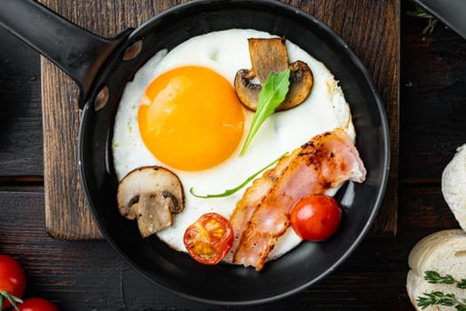 Fried Egg with ingredient in cast iron frying pan, on old dark wooden table background, top view flat lay