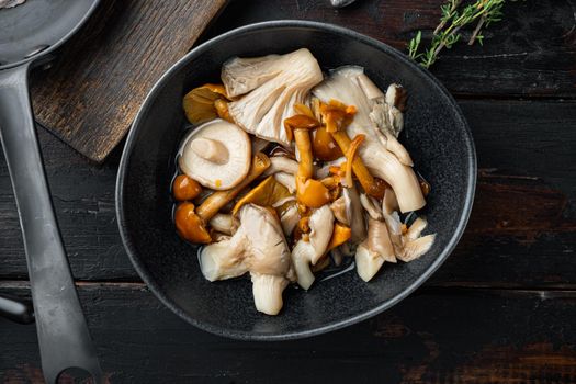 Marinated mushrooms set, on old dark wooden table background, top view flat lay