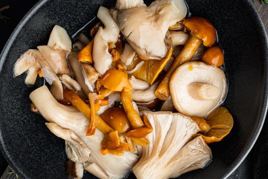 Pickled mushrooms set, on black background, top view flat lay
