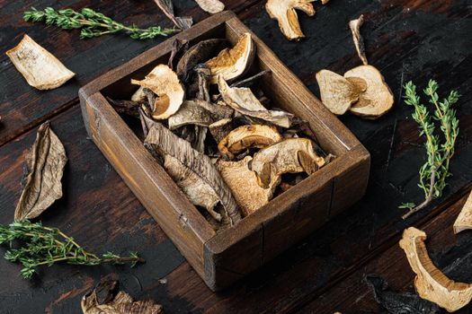 Dried wild mushrooms set, on old dark wooden table background