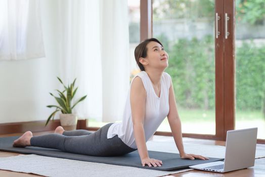 Beautiful asian woman staying fit by exercising at home for healthy trend lifestyle