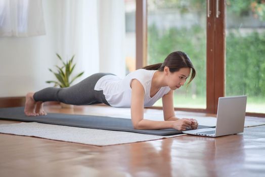 Beautiful asian woman staying fit by exercising at home for healthy trend lifestyle