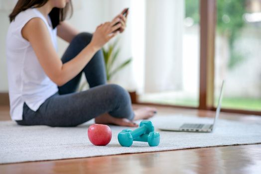 Asian woman staying fit by exercising at home for healthy trend lifestyle