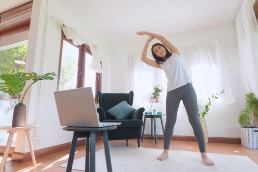 Beautiful asian woman staying fit by exercising at home for healthy trend lifestyle