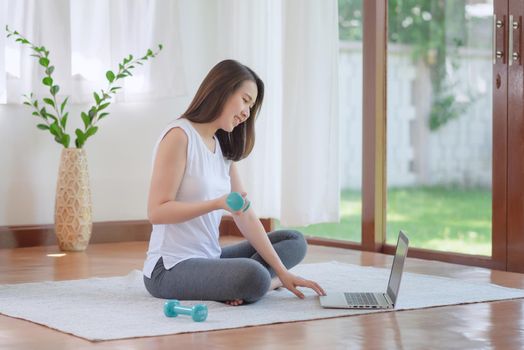 Beautiful asian woman staying fit by exercising at home for healthy trend lifestyle