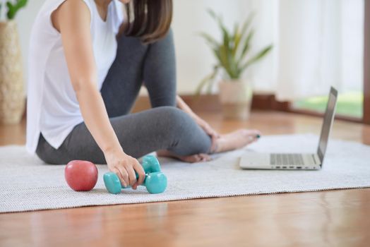 Asian woman staying fit by exercising at home for healthy trend lifestyle